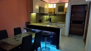 A compact kitchen with a dining area, a refrigerator, and a microwave. - 2-Bed property in Makadi Heights (MAKADI BAY)