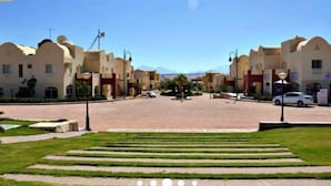 A residential area with a central open space, surrounded by houses with similar architectural styles. - 2-Bed property in Makadi Heights (MAKADI BAY)