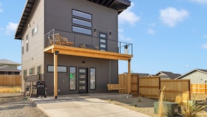 A two-story building with a balcony, a covered patio, and a front door. - Modern Downtown Talent Dream (Talent)