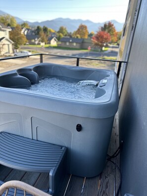 A hot tub on a wooden deck with a view of houses and mountains in the background. - Modern Downtown Talent Dream (Talent)