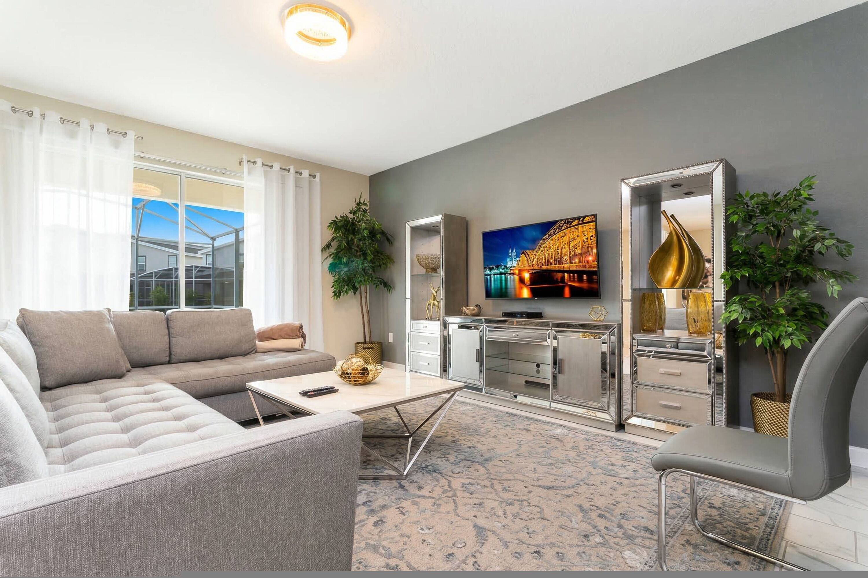 A modern living room with a sofa, coffee table, TV, and kitchen area.