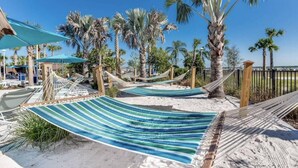 A beach with hammocks, palm trees, and a clear blue sky. - Brand New Windsor Island 5 Suites (Davenport)
