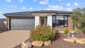 A single-story house with a garage, a front porch, and a landscaped front yard with rocks and shrubs. - Seagrove Getaway in Cowes (Cowes)