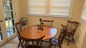 Un comedor con una mesa redonda de madera y cuatro sillas de madera.