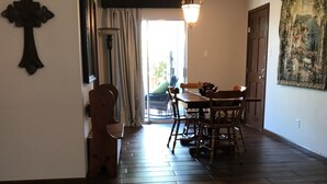 Ein Essbereich mit einem Holztisch und Stühlen, einer Chandelüster und einem großen Gemälde an der Wand.
