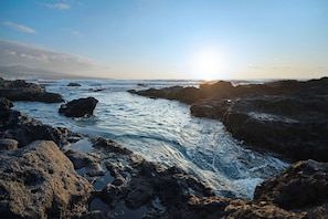 A rocky shoreline with waves crashing against the rocks.