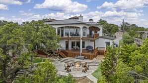A two-story house with a covered patio, outdoor seating, and a fire pit. - Riviera Paradise | Lake Access (Canyon Lake)