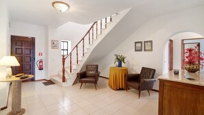 A spacious living area with a staircase, a fireplace, and a dining area. - Casa das Areias with Private Pool, Wi-Fi, and Air Conditioning (Porches)