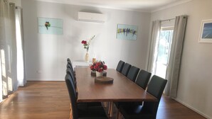 A dining area with a wooden table, black chairs, and a vase with flowers.