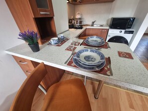 A compact kitchen with wooden cabinets, a microwave, and a sink. - 1BR Homey Duplex 300mbps WIFI 2 Floor with washer (Bansko)