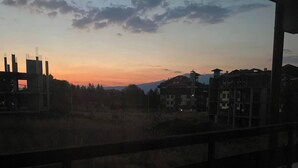 Vista de um horizonte urbano ao pôr do sol, com edifícios e céu claro.