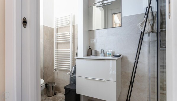 A modern bathroom with a white vanity, a glass shower enclosure, and a towel rack. - Italianway - Marco d Agrate 27 (Milan)
