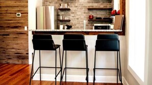 A modern kitchen with a brick backsplash, three black bar stools, and a stainless steel refrigerator. - Downtown+HotTub+Wifi+FreeParking @ 151 Spring Suite E (Eureka Springs)