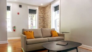 Ein modernes Wohnzimmer mit einer Couch, einem Couchtisch und einer Wand mit Steinverkleidung.