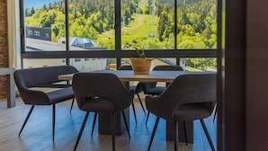 Ein moderner Essbereich mit großem Fenster, einem Tisch und vier Stühlen.