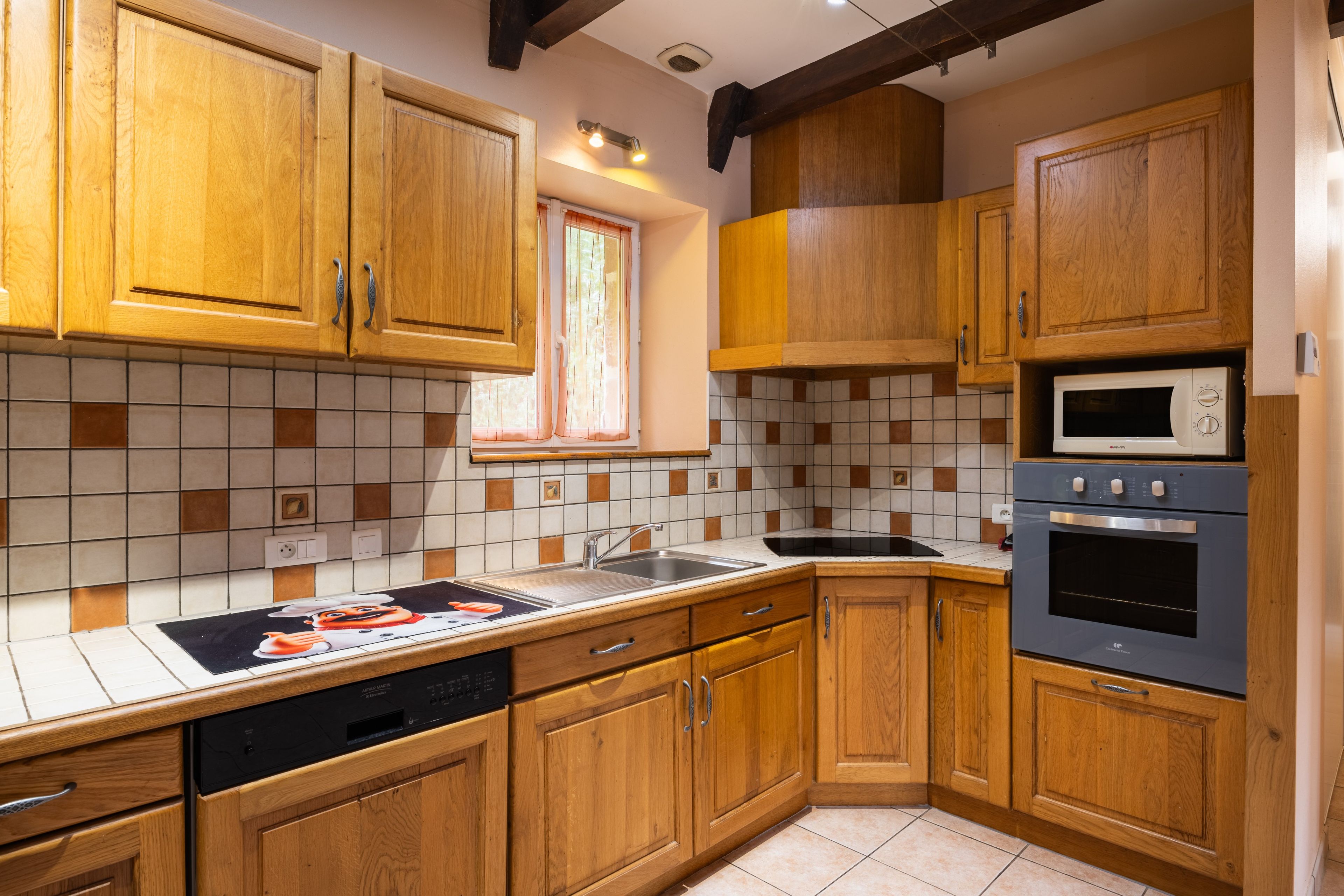 A kitchen with wooden cabinets, a microwave, an oven, and a dishwasher.