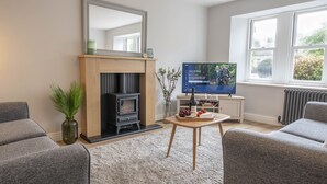 Uma sala de estar com lareira, televisão e um espaço de estar acolhedor.