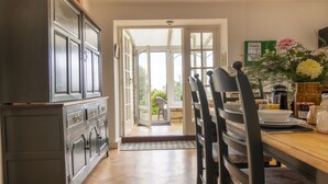 Una cocina con armarios de madera, una mesa de comedor con sillas y vistas al exterior.