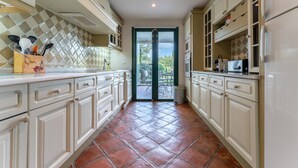 A kitchen with white cabinets, a tiled backsplash, and a view to the outside.