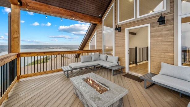 Una terraza con un pozo de fuego, zona de estar y vistas del paisaje.