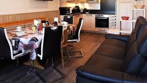 Eine moderne Küche mit Mikrowelle, Backofen und Essbereich mit Tisch und Stühlen.