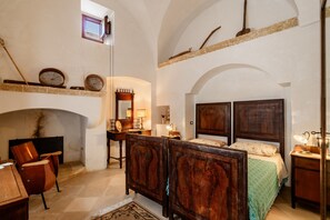 Une chambre à coucher avec un lit en bois, une cheminée, un bureau et une chaise.