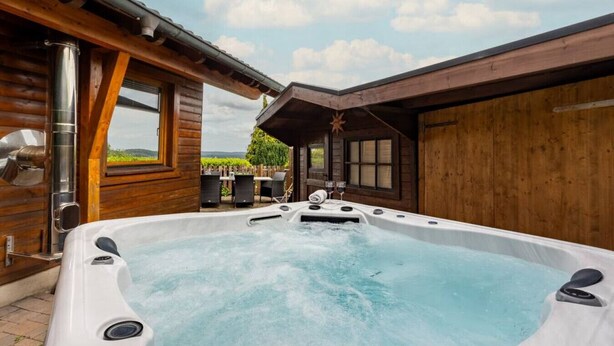 Un jacuzzi en una cabaña de madera con vistas al exterior.