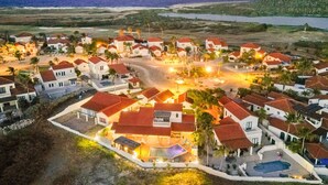 A coastal resort with multiple villas, a swimming pool, and a beach view. - Luxury 4BR Villa in Tierra del Sol by Bocobay (Noord)