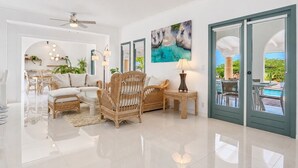 A spacious living area with a sofa, chairs, a coffee table, a lamp, and a painting on the wall. - Luxury 4BR Villa in Tierra del Sol by Bocobay (Noord)