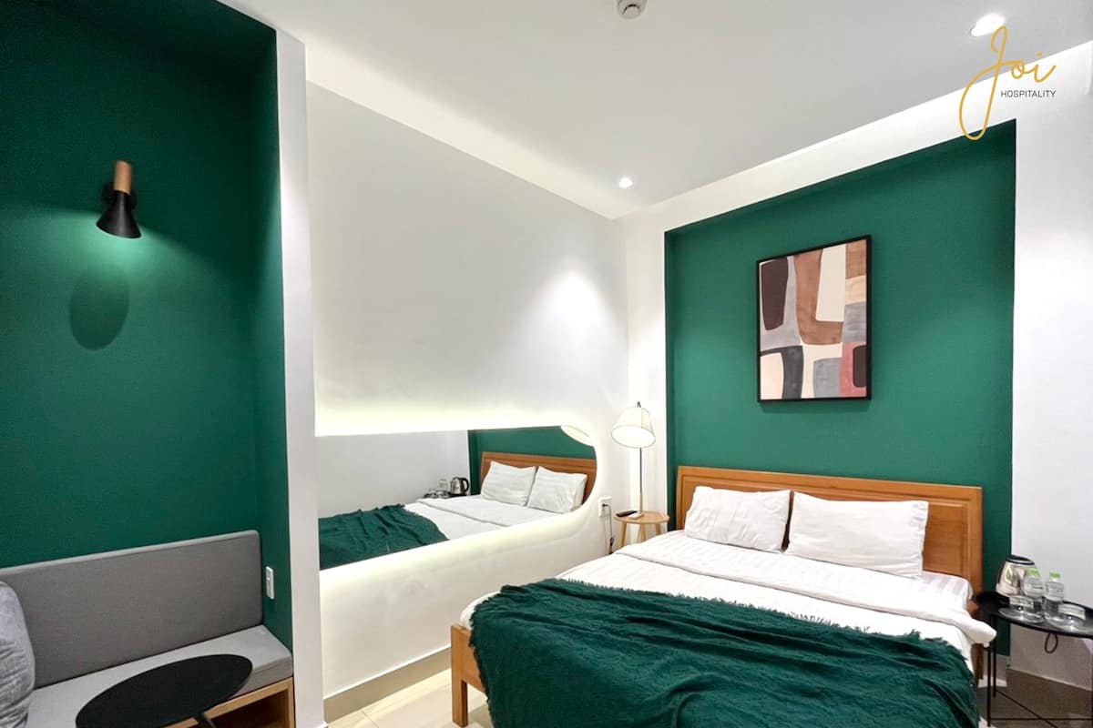 Une chambre d’hôtel moderne avec deux lits, un coin salon et une petite table avec des commodités.