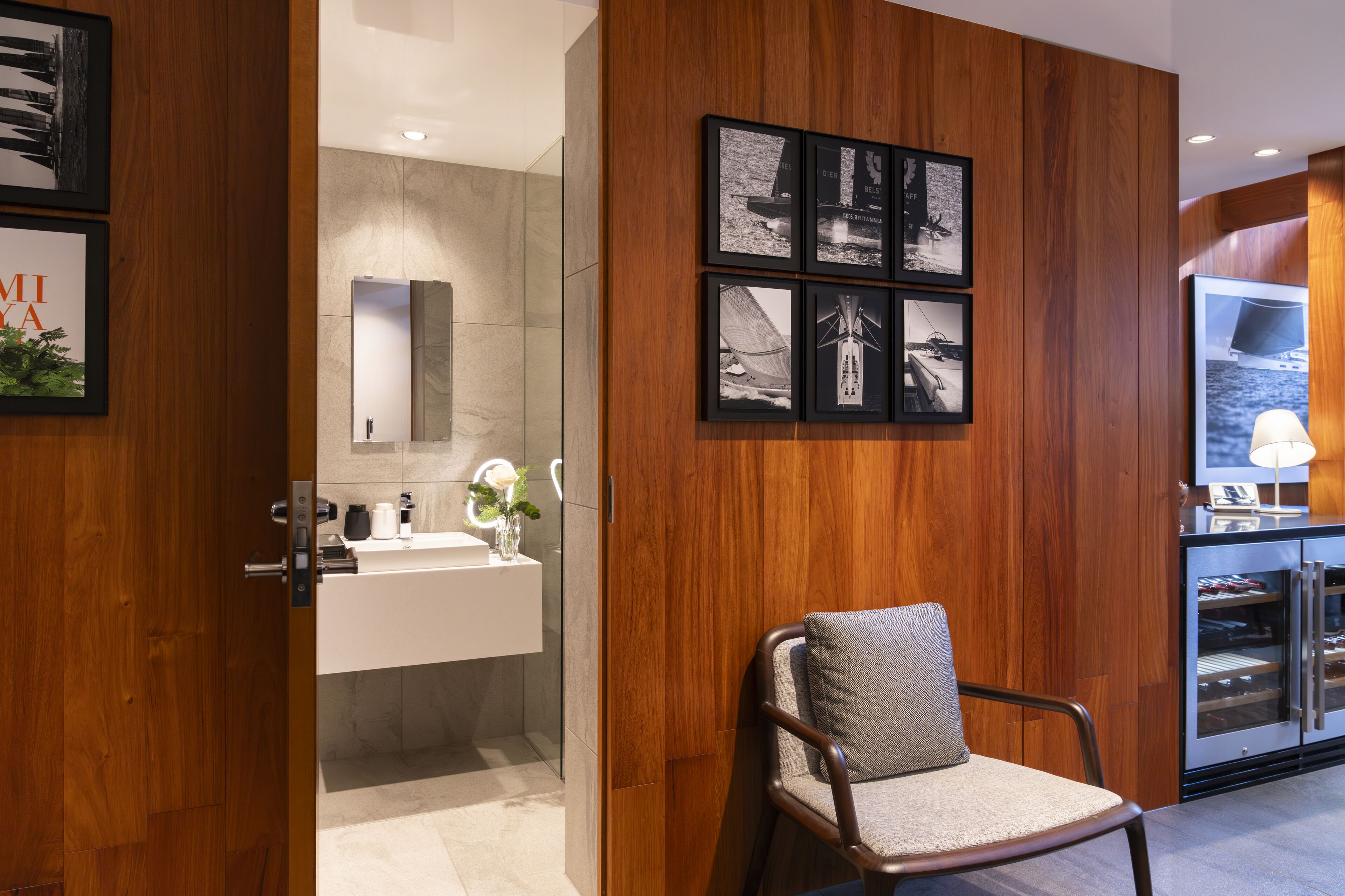 Une salle de bain moderne avec un mur recouvert de panneaux en bois, un lavabo et un miroir.