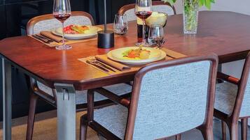 A dining table set with plates, glasses, and a vase of flowers.