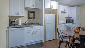 A compact kitchen with white cabinets, a refrigerator, a microwave, and a coffee maker. - Your Montrose Estate! Sleeps 18/8BR/4BA/4PA<br> (Houston)