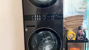 Eine schwarze LG Wascher- und Trockner-Kombination mit Ober- und Frontlader, einer Bedienfeld und einem kleinen Staufach.
