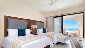 A hotel room with two beds, a large window with a view of the ocean, a ceiling fan, and a seating area with a table and chairs. -  VILLA LA VALENCIA, LOS CABOS, TWO BEDROOM OCT28-NOV5TH (San José del Cabo)