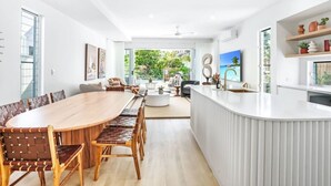 A modern kitchen with a large island, white cabinetry, and a view of the outdoors. - The Santana Collection TWO - Luxury Villa Retreat in Palm Cove with Private Pool (Palm Cove)