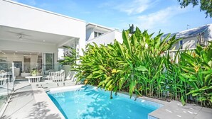 A modern house with a swimming pool surrounded by lush greenery. - The Santana Collection TWO - Luxury Villa Retreat in Palm Cove with Private Pool (Palm Cove)
