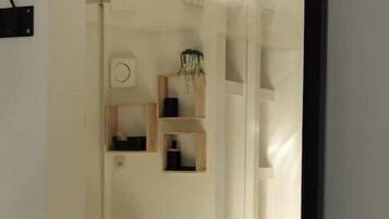 A modern bathroom with a wooden vanity, a sink, and built-in shelves.