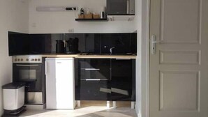 A compact kitchen with a microwave, stove, and dishwasher. - Appartement Proche Gare et Centre-ville D'amiens (Rivery)