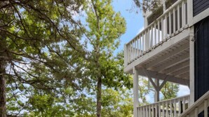 A wooden deck with a staircase leading to a second-story balcony overlooking a lake. - Blue Haven-Margaritaville-Private Dock and Kayaks! (Osage Beach)