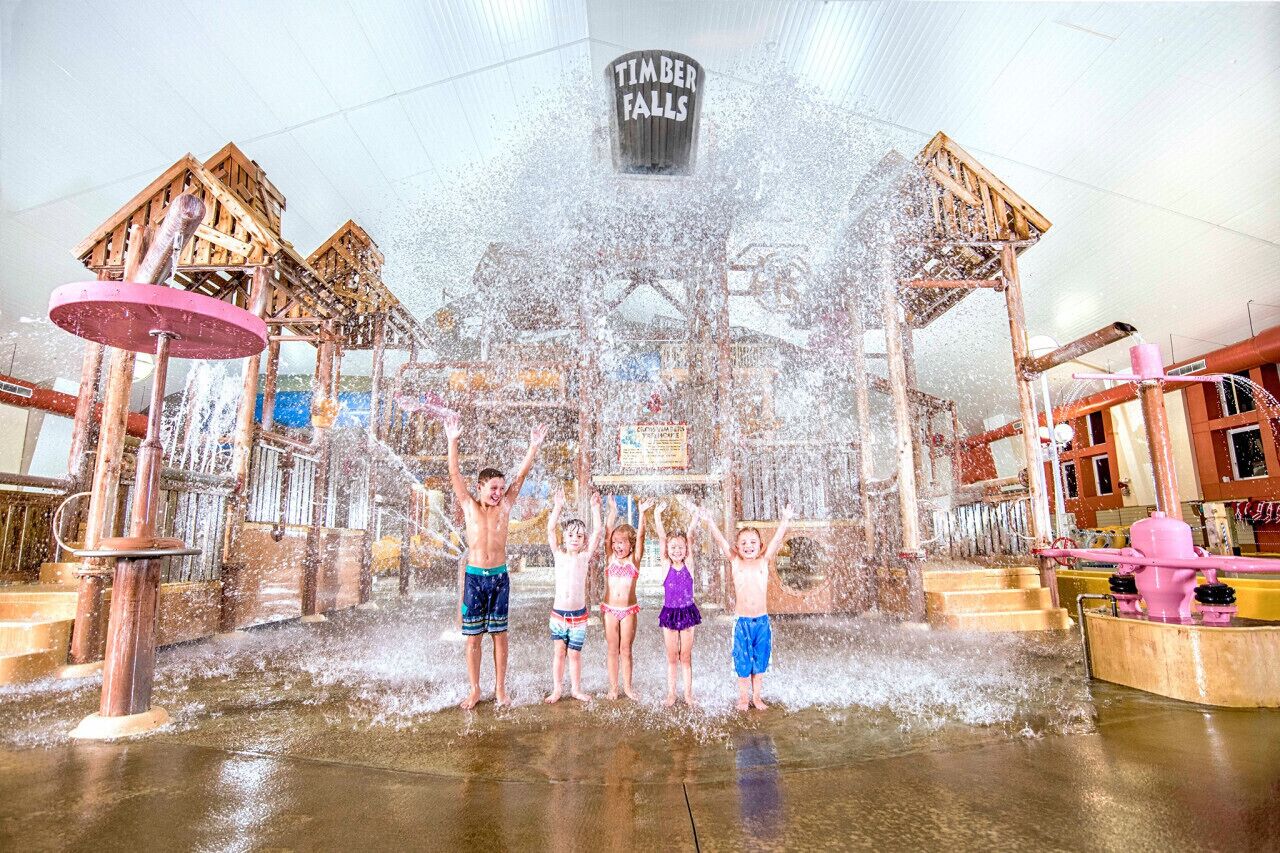 A water play area with multiple water jets and wooden structures.