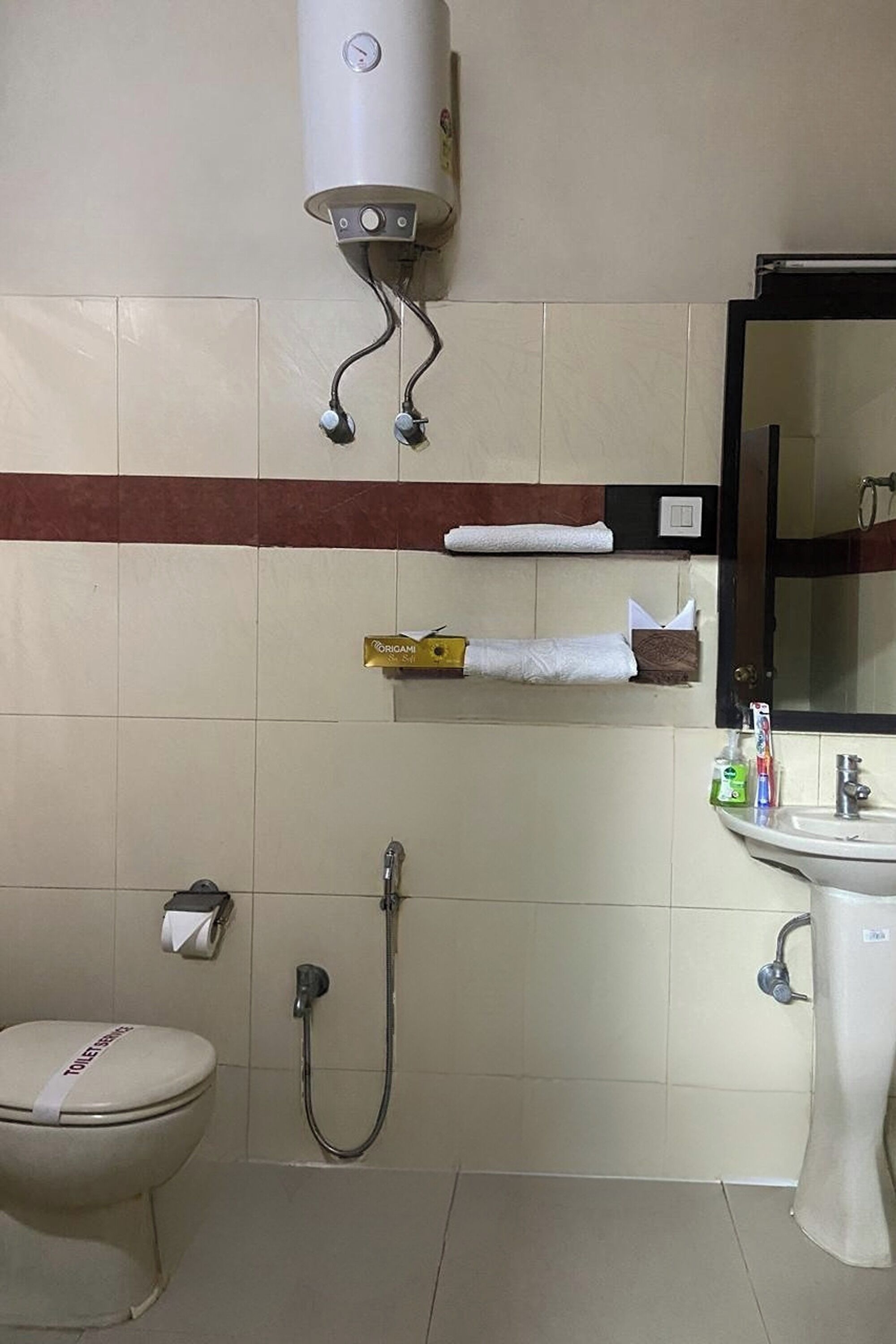 Un baño con inodoro, lavamanos, toallero, ducha y secatoallas.