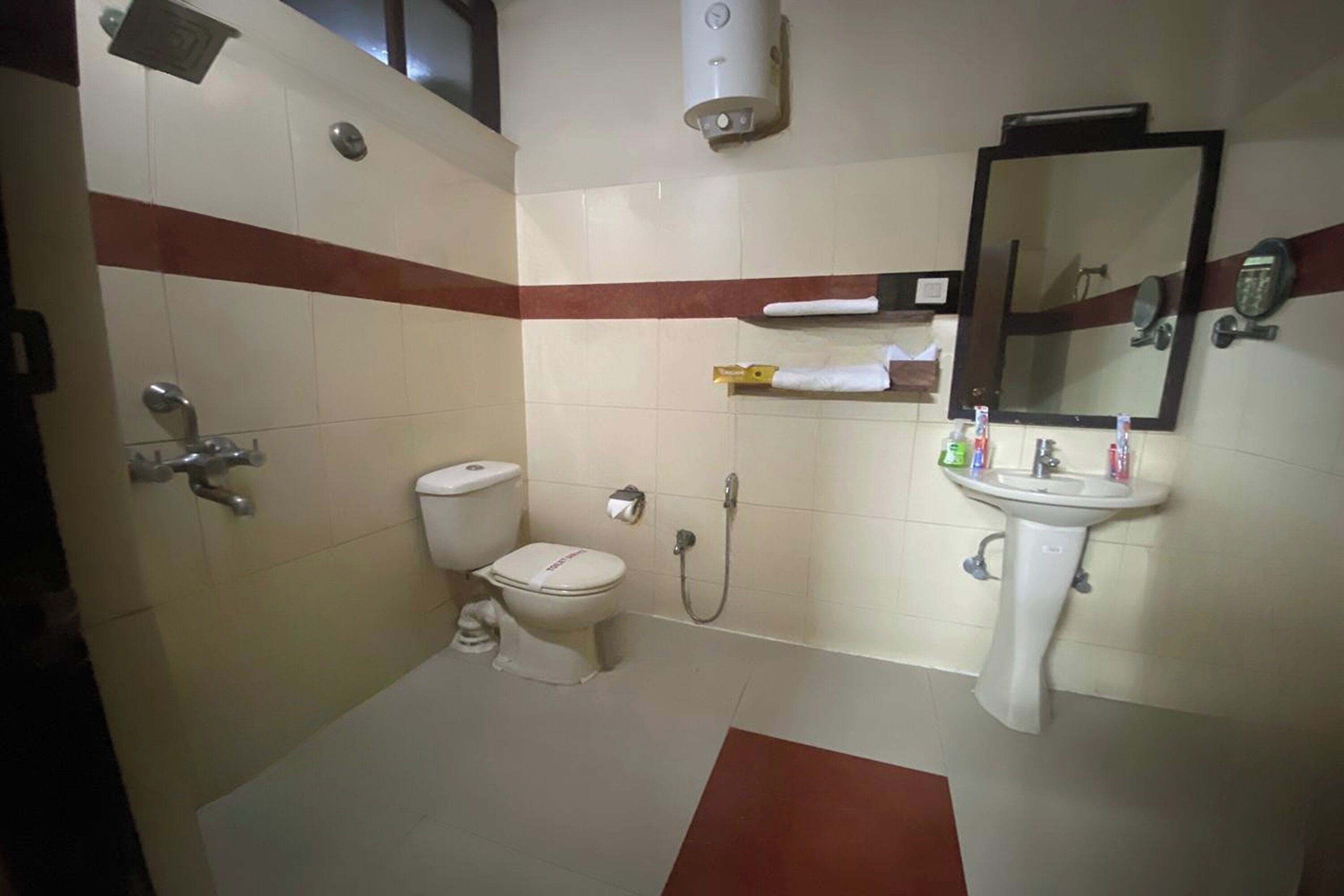 A bathroom with a toilet, shower, and sink.
