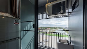 Een balkon met uitzicht op een parkeerplaats en een rivier.