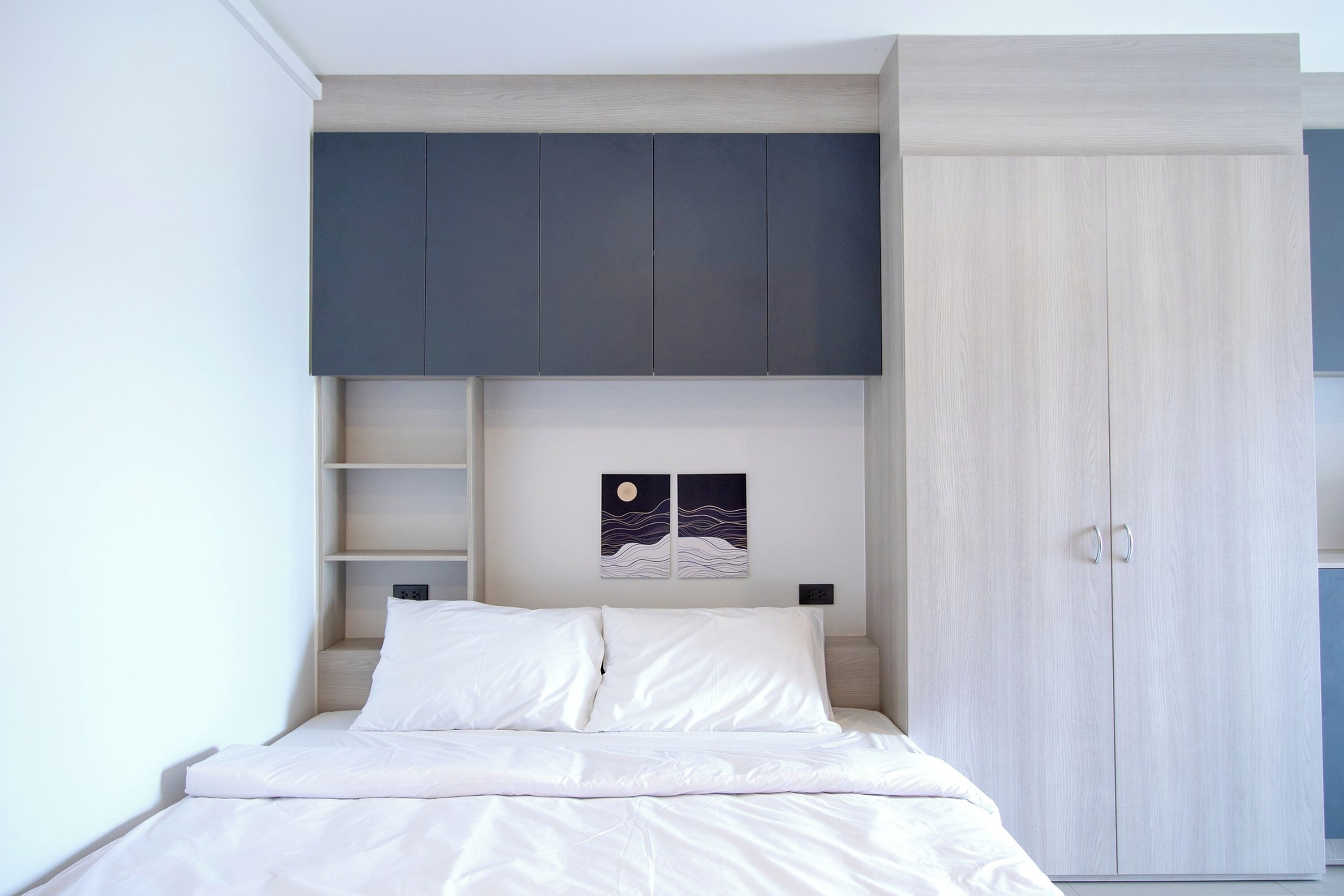 A bedroom with a bed, a wardrobe, and a shelf unit.