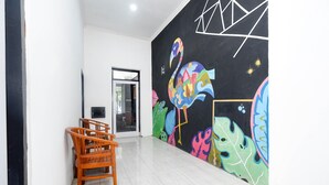Een kamer met een zwart behang, een houten stoel en een deur naar een andere kamer.