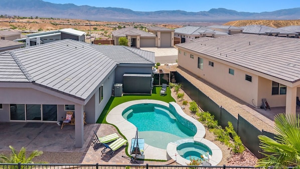 A residential area with modern houses, a swimming pool, and a view of mountains.