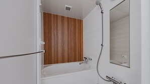 A modern bathroom with a wooden vanity, a bathtub, a shower, and a mirror. - Folio Sakura Shinsaibashi Osaka (Osaka)