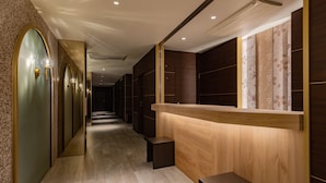 A hallway with a reception desk, mirrored walls, and a tiled floor. - Folio Sakura Shinsaibashi Osaka (Osaka)