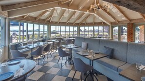 A restaurant with a checkered floor, wooden beams, and large windows offering a view of the outdoors. - Monaco Resort Apartment with Access to Swimming Pool and Gym Facilities (Nelson)